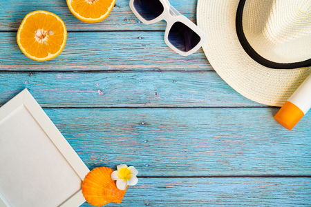 Beautiful summer holiday, Beach accessories, orange, sunglasses, hat and sunblock on wooden backgroundsの写真素材