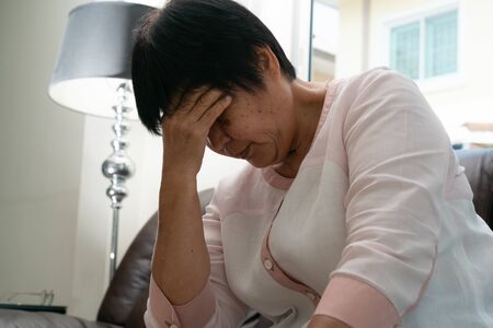 old woman suffering from headache, stress, migraine, health problem conceptの写真素材