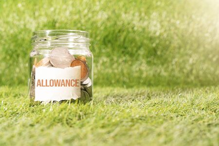allowance money, coins in glass jar for money saving financial conceptの写真素材