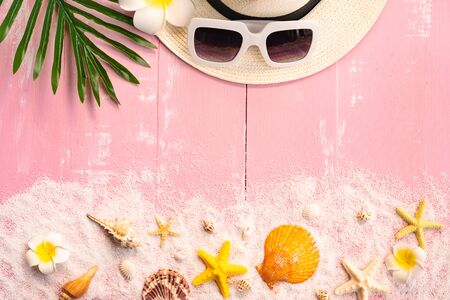 Beautiful summer holiday, Beach accessories, seashells, sand, hat, sunglasses and palm leave on wooden backgroundsの写真素材