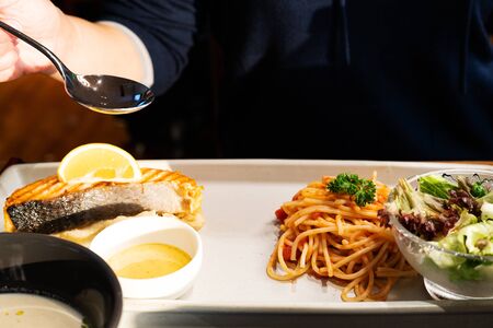 Italian spaghetti with a tasty grilled salmon steak and mashed sweet potatoの写真素材