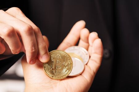cryptocurrency Bitcoin. Women hold the cryptocurrency coin on hand. Physical bitcoins gold coinの写真素材