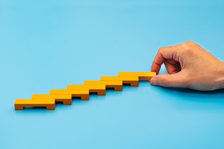 Business concept for growth success process, hand stacking wood block as step stairの写真素材