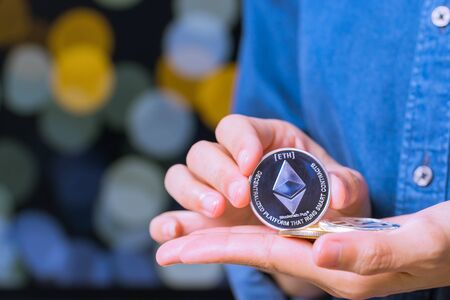 cryptocurrency coins - Ethereum. Women hold the cryptocurrency coin on handの写真素材