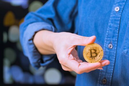 cryptocurrency coins - Bitcoin. Women hold cryptocurrency coin on handの写真素材