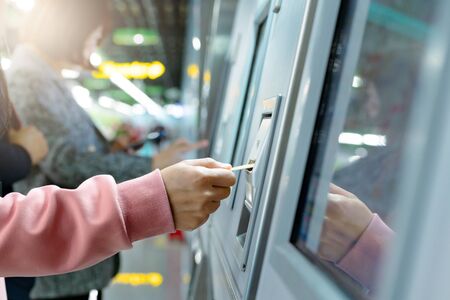 Woman take a train ticket after buy from subway ticket machine. Transportation conceptの写真素材