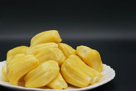 Fresh jackfruit slices on a white plate. sweet yellow jackfruit ripe. vegetarian, vegan, raw food. Exotic tropical fruit - isolatedの写真素材