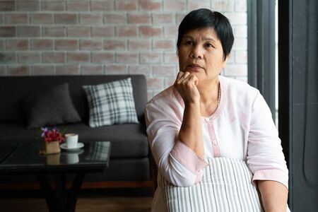 senior asia woman thinking and looking sideways, thinking and wonderingの写真素材