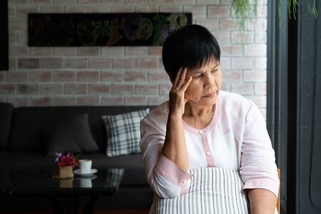 old woman suffering from headache, stress, migraine, health problem conceptの写真素材