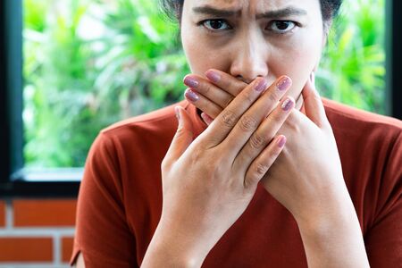 Woman with bad breath covering mouth, halitosis conceptの写真素材