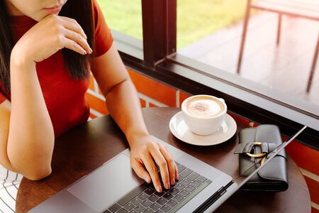 woman hands typing on laptop keyboard. Woman working at office with coffeeの写真素材