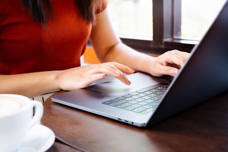 woman hands typing on laptop keyboard. Woman working at office with coffeeの写真素材