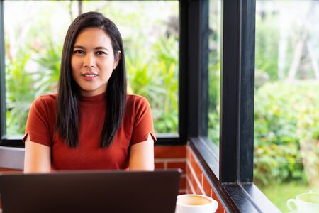 woman hands typing on laptop keyboard. Woman working at office with coffeeの写真素材