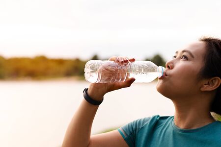 Fitness Asia Woman Drinking Water after Runningの写真素材