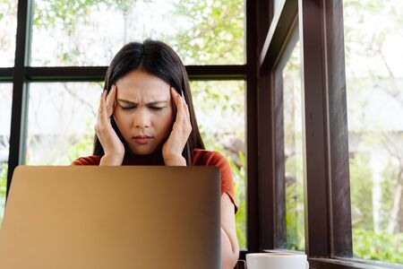 woman headache after long working on laptop. office syndrome conceptの写真素材