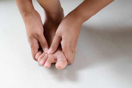 Woman massaging her painful foot and finger, healthcare and medical conceptの写真素材
