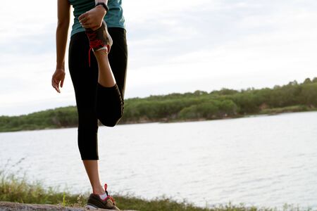 sport woman is stretching muscle after workoutの写真素材