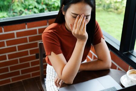 woman headache after long working on laptop. office syndrome conceptの写真素材