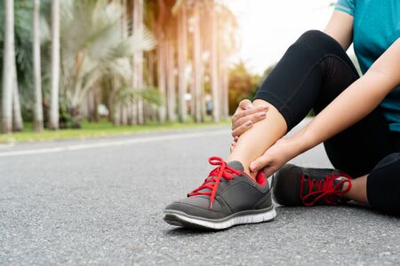 fitness woman runner feel pain on ankle leg. Outdoor exercise activities conceptの写真素材