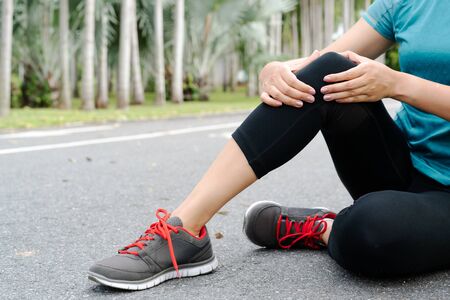fitness woman runner feel pain on knee. Outdoor exercise activities conceptの写真素材