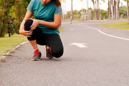fitness woman runner feel pain on knee. Outdoor exercise activities conceptの写真素材