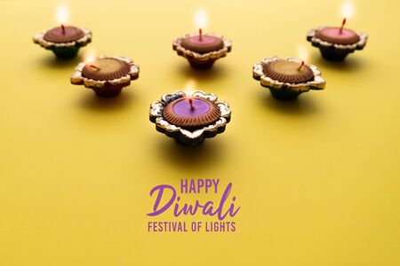 Happy Diwali - Clay Diya lamps lit during Dipavali, Hindu festival of lights celebration. Colorful traditional oil lamp diyaの写真素材