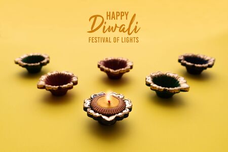 Happy Diwali - Clay Diya lamps lit during Diwali, Hindu festival of lights celebration. Colorful traditional oil lamp diyaの写真素材