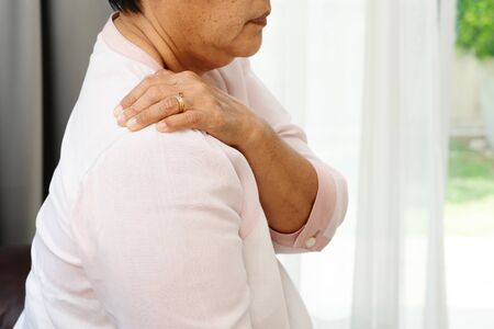 neck and shoulder pain, old woman suffering from neck and shoulder injury, health problem conceptの写真素材