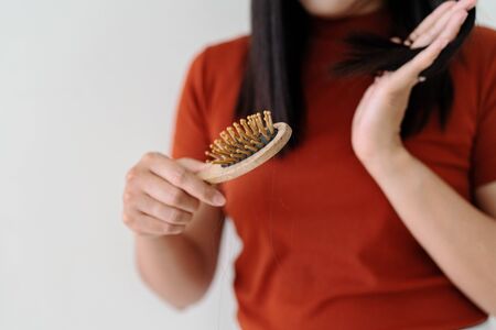 long loss hair on woman brush with and woman looking at her hairの写真素材