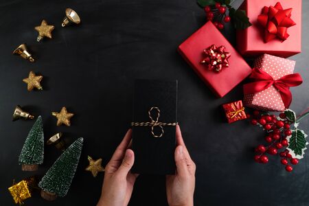 Hand holding christmas present in xmas decoration backgroundの写真素材