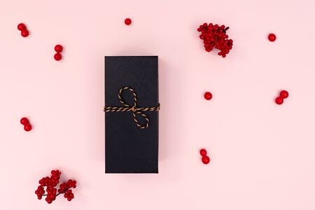 Christmas Gift box, red cherry on pink background. Christmas, winter, new year concept. Flat lay, top view, copy spaceの写真素材