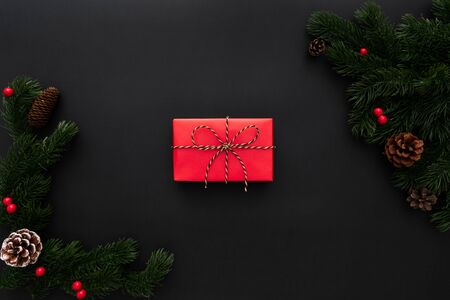 Christmas gift box and pine tree with xmas decoration on black backgroundの写真素材