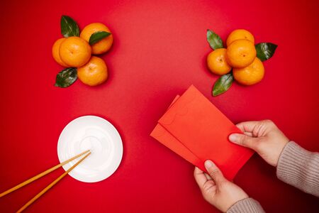 Flat lay Chinese lunar new year traditional food and offering red envelope on table topの写真素材
