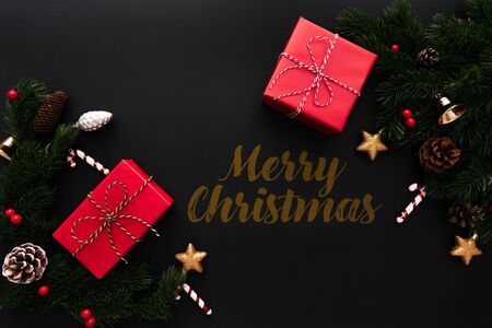 Christmas gift box and pine tree with xmas decoration on black backgroundの写真素材