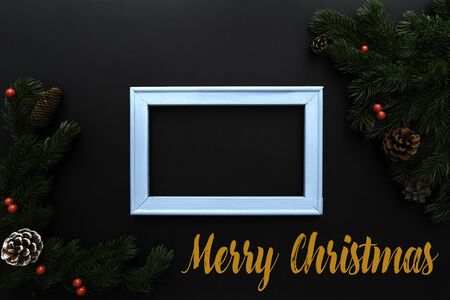 Christmas pine tree and photo frame with xmas decoration on black backgroundの写真素材