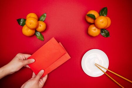 Flat lay Chinese lunar new year traditional food and offering red envelope on table topの写真素材