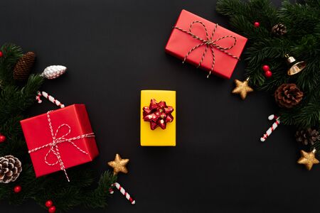 Christmas gift box and pine tree with xmas decoration on black backgroundの写真素材