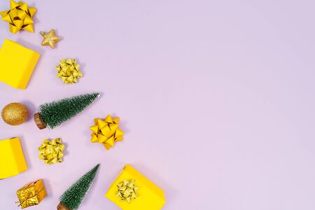 Christmas decoration. Gifts, yellow and golden decorations on purple background. Christmas, winter, new year concept. Flat lay, top view, copy spaceの写真素材