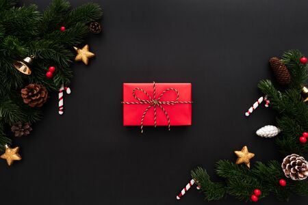 Christmas gift box and pine tree with xmas decoration on black backgroundの写真素材