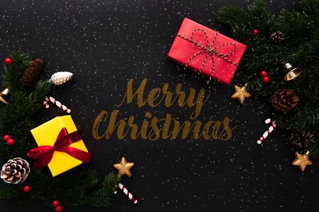 Christmas gift box and pine tree with xmas decoration on black backgroundの写真素材