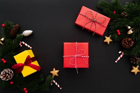 Christmas gift box and pine tree with xmas decoration on black backgroundの写真素材