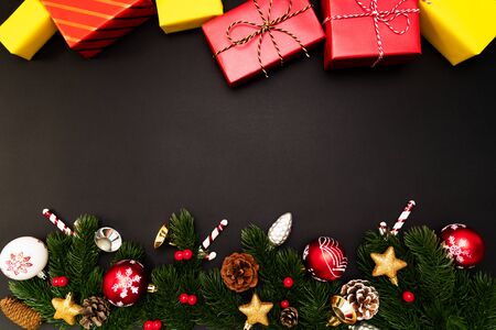 Christmas gift box and pine tree with xmas decoration on black backgroundの写真素材