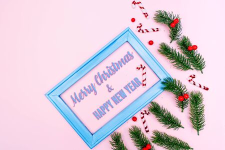 Christmas pine tree and photo frame with xmas decoration on pink backgroundの写真素材