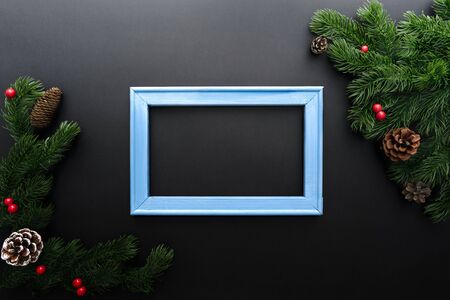 Christmas pine tree and photo frame with xmas decoration on black backgroundの写真素材