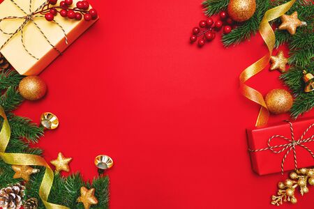 Christmas present and pine tree with xmas decoration on Red backgroundの写真素材