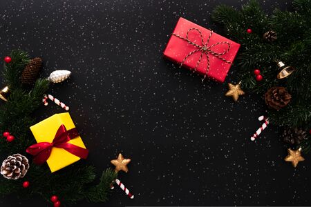 Christmas gift box and pine tree with xmas decoration on black backgroundの写真素材