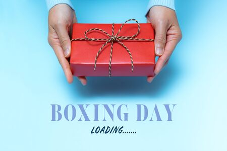 Boxing Day loading, young woman hand with a gift box offer to receiverの写真素材