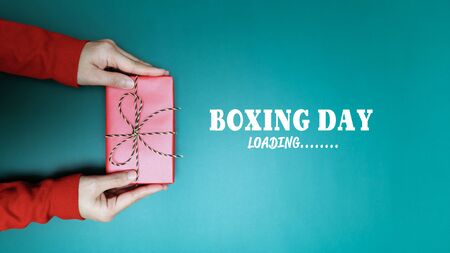 Boxing Day loading, young woman hand with a gift box offer to receiverの写真素材