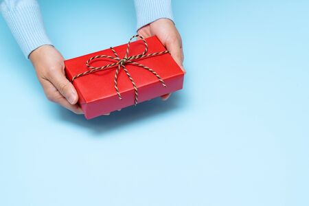 Boxing Day loading, young woman hand with a gift box offer to receiverの写真素材