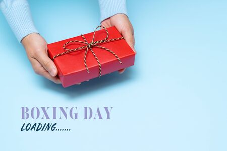 Boxing Day loading, young woman hand with a gift box offer to receiverの写真素材